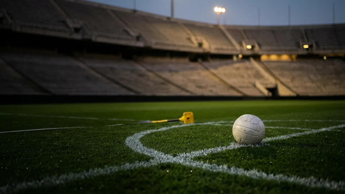 Leeres Fußballstadion unter Flutlicht, ein Ball auf dem Anstoßpunkt
